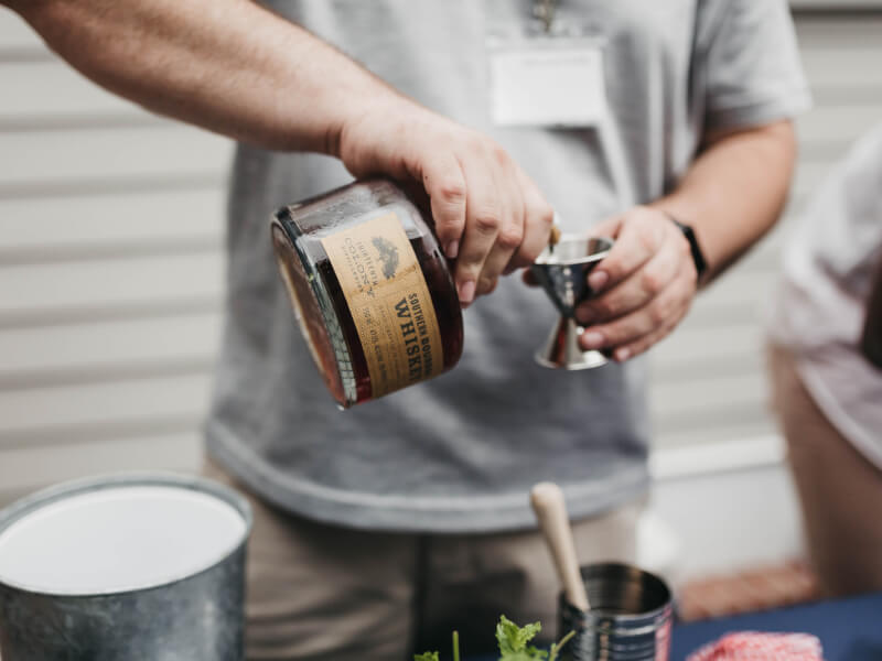 man pouring a whisky cocktail